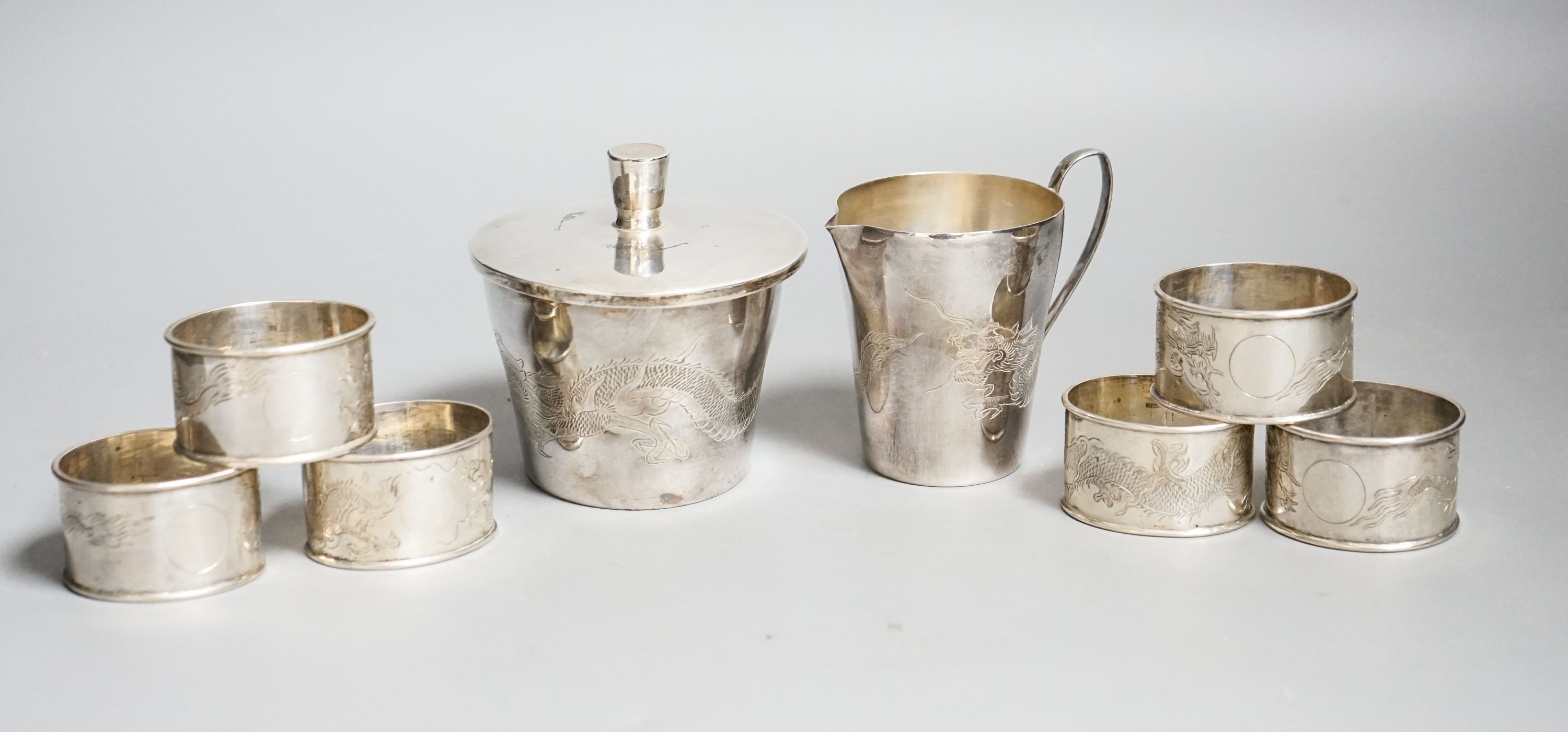 A Chinese sterling pot and cover by Kingsburg, Hong Kong, 9.4cm, a similar cream jug and six napkin rings by Wang Hing